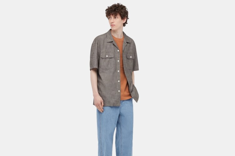 A model wearing the Chambray Short-Sleeve Workshirt from J.W. Anderson and Uniqlo