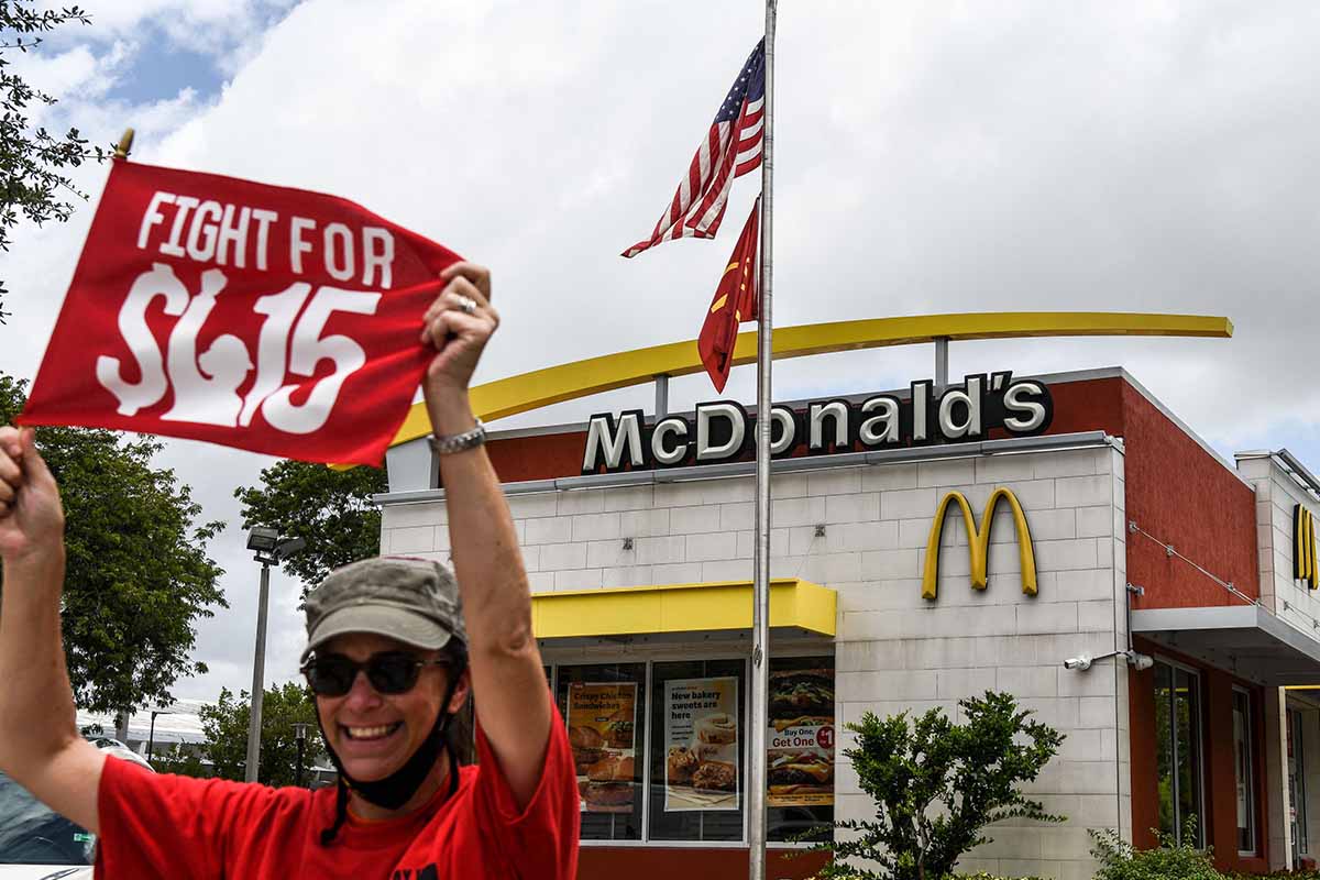 An employee of McDonald's protests outside a branch restaurant for a raise in their minimum wage to $15 an hour, in Fort Lauderdale on May 19, 2021