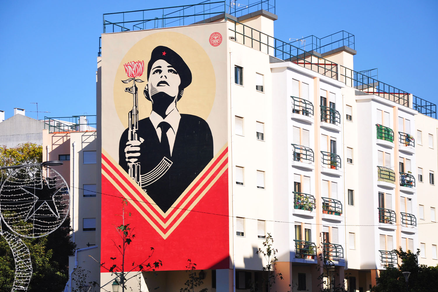 Shepard Fairey's mural of a woman wearing a revolutionary beret and holding a rifle with a carnation in the muzzle in Lisbon, Portugal