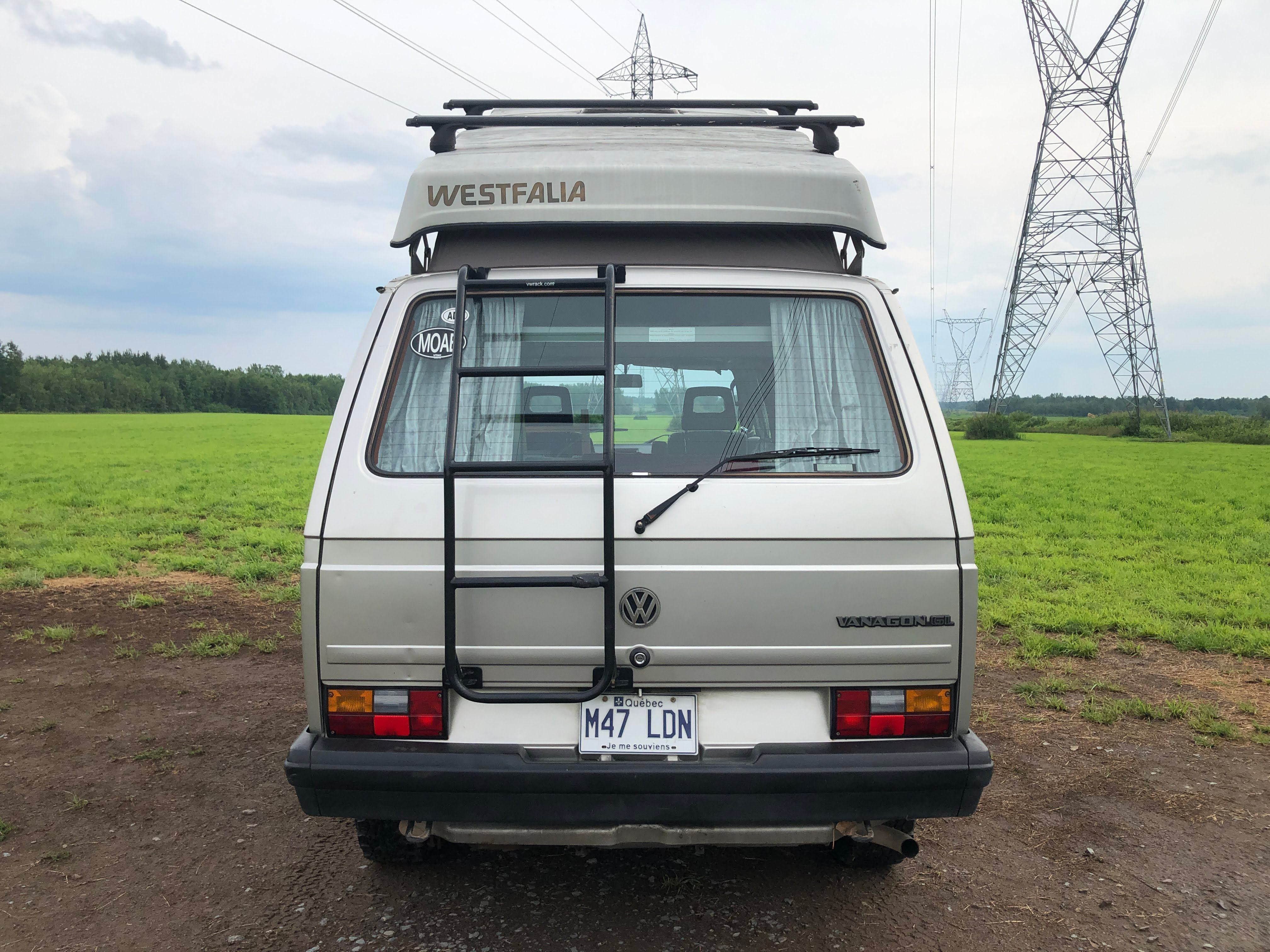 The rear end of a 1990 Volkswagen Vanagon Westfalia. We spoke with someone who owns the camper van to get some insight into buying one.