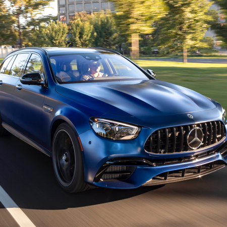 A blue 2021 Mercedes-AMG E63 S 4MATIC Wagon driving down the street. Want a high-performance station wagon? Read our review of this.