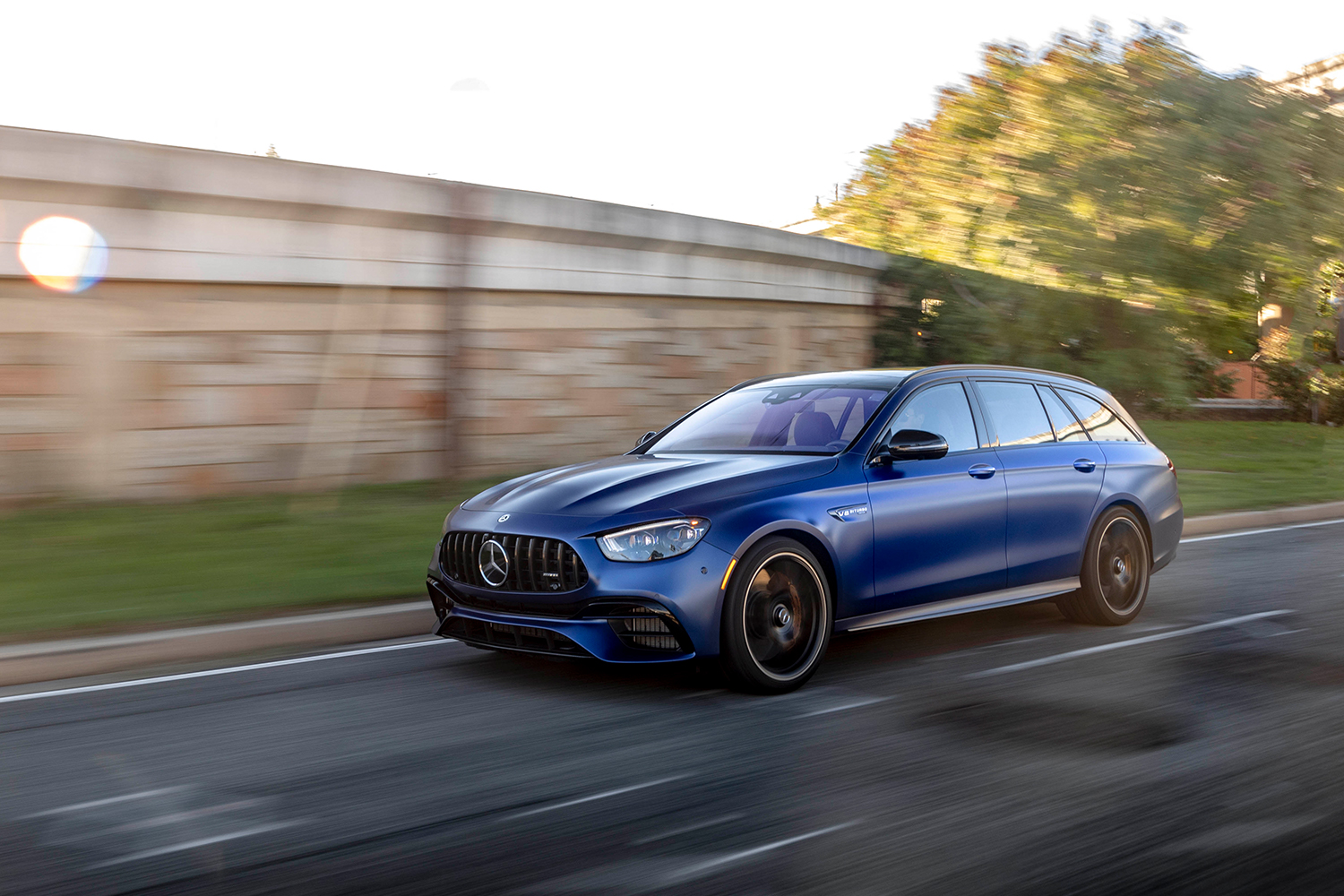 A blue 2021 Mercedes-AMG E63 S 4MATIC Wagon driving fast down city streets