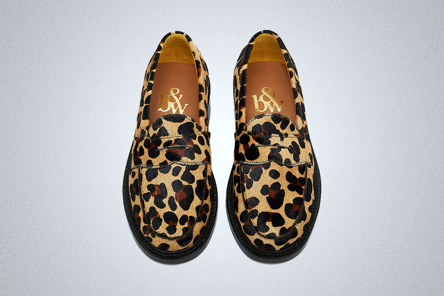 A pair of summer leopard colored loafers from Blackstock & Weber on a grey background