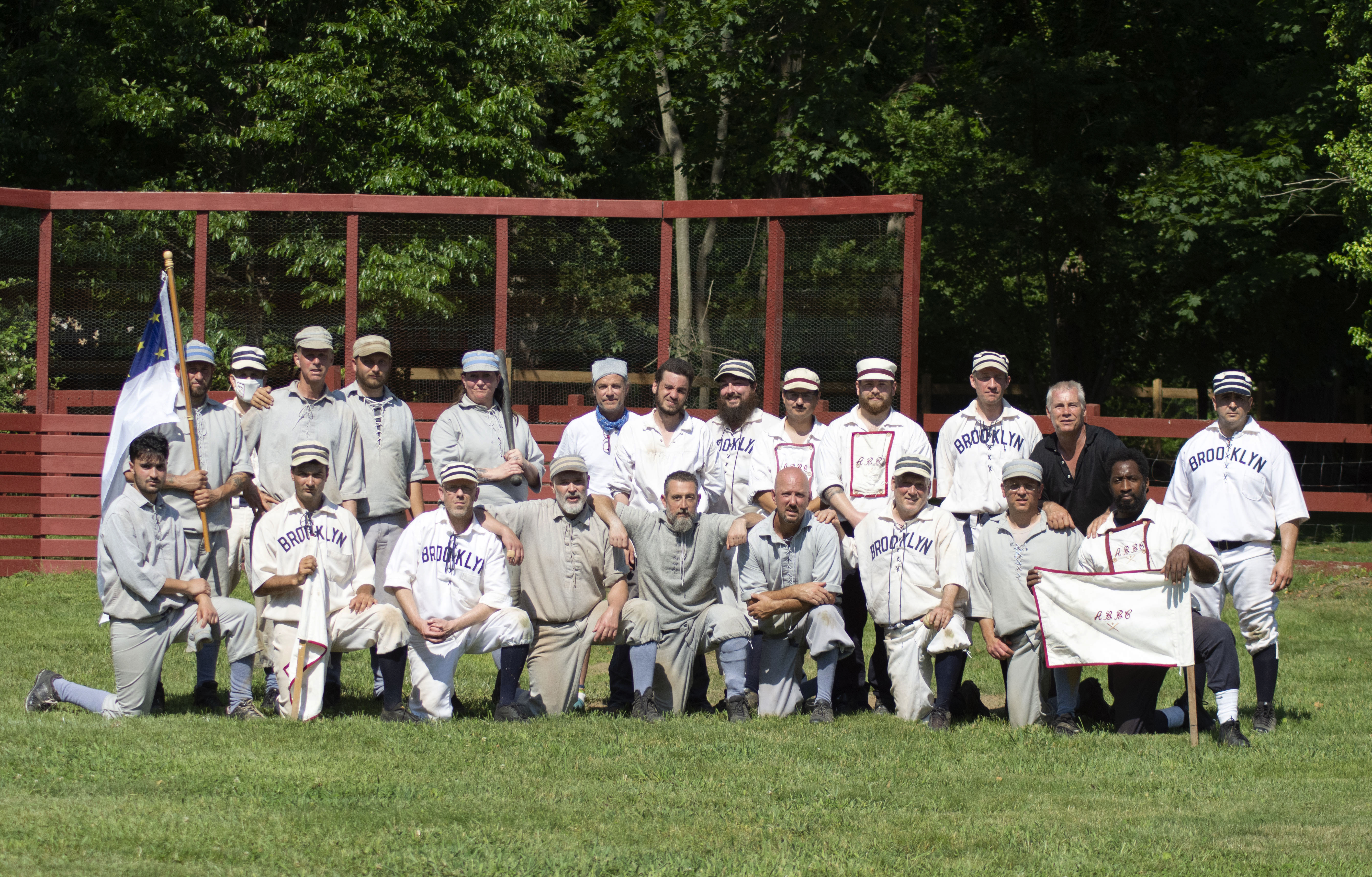 The Atlantics and Grays join arms for a post-game picture at a vintage baseball game