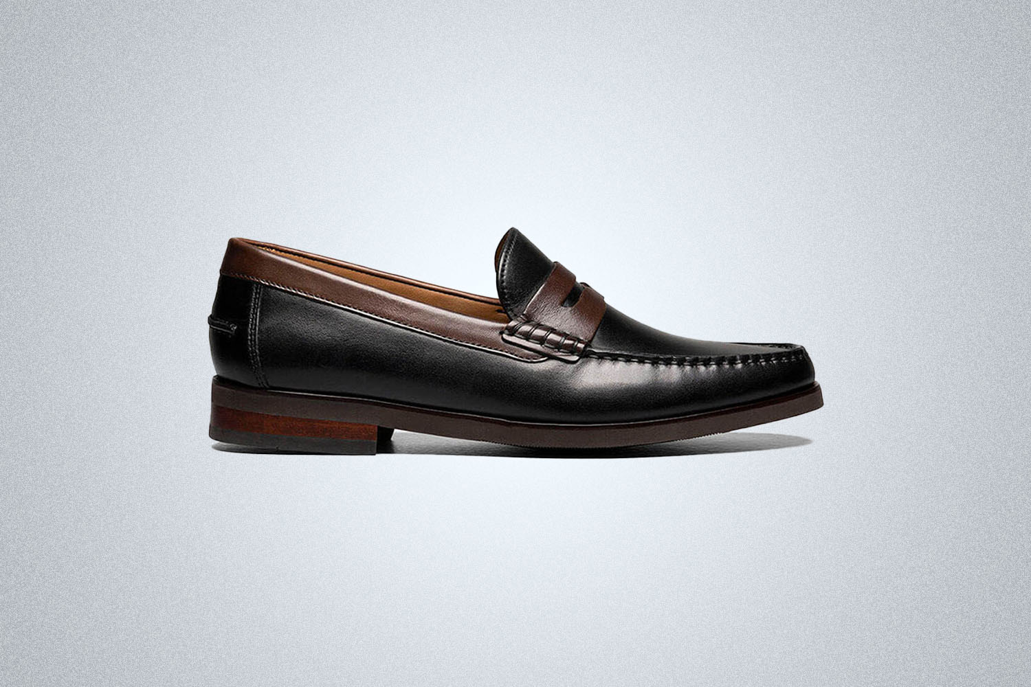 a pair of black and brown loafers from Florsheim on a grey background