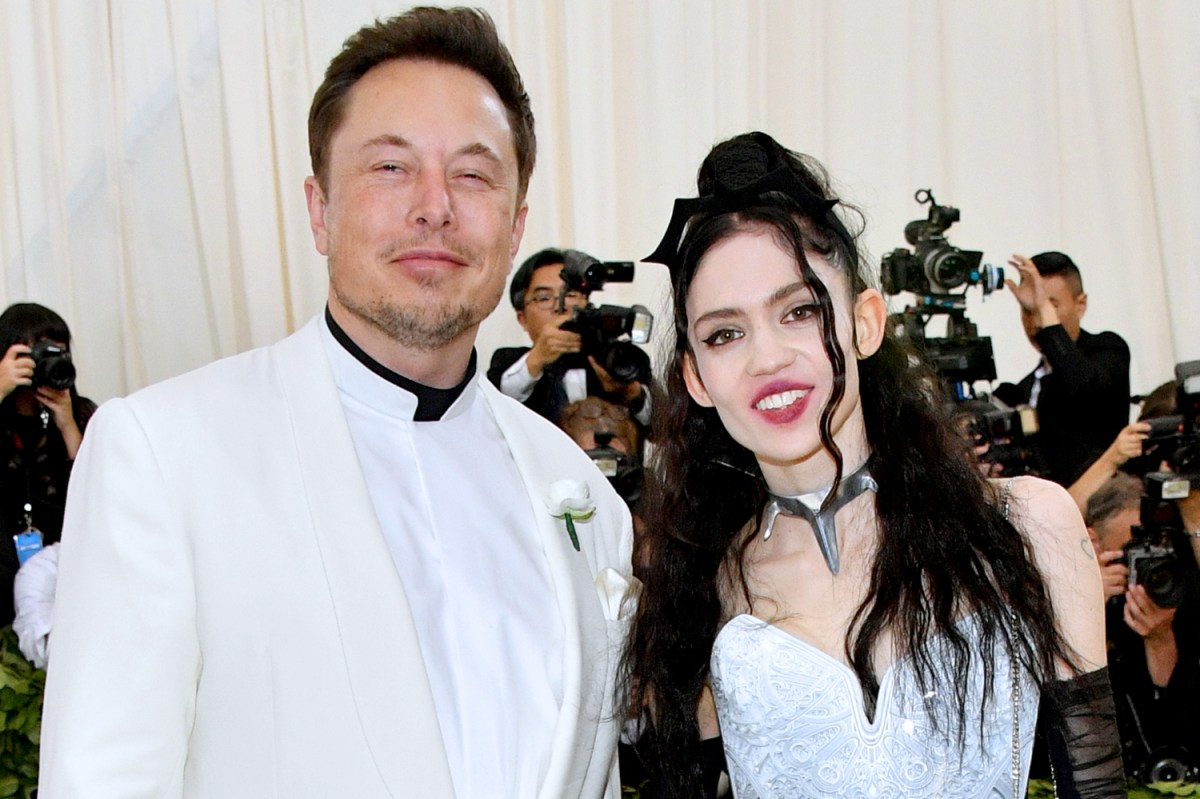 Elon Musk and Grimes smile for a photo together at the 2018 Met Gala