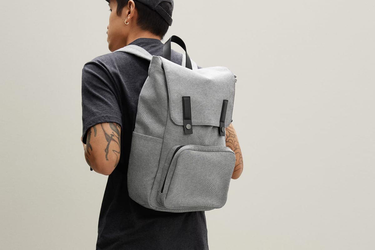 A man in a t-shirt wearing Everlane's The Modern Snap Backpack