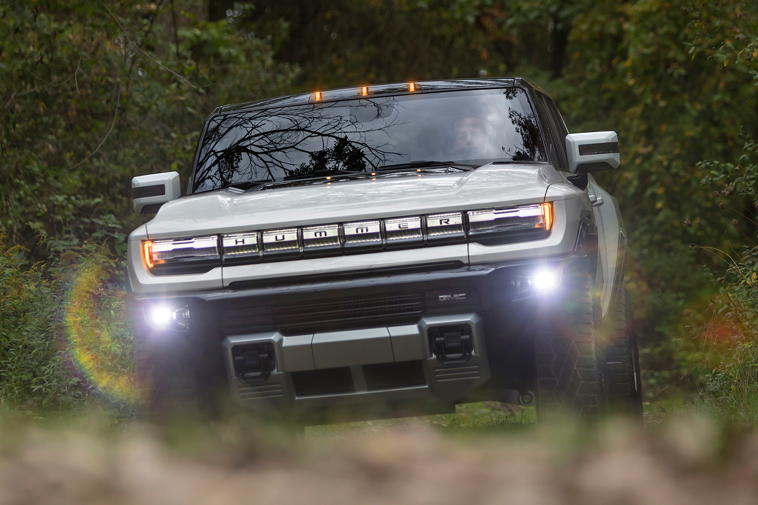 The GMC Hummer EV supertruck, a new electric pickup truck, driving through the dirt