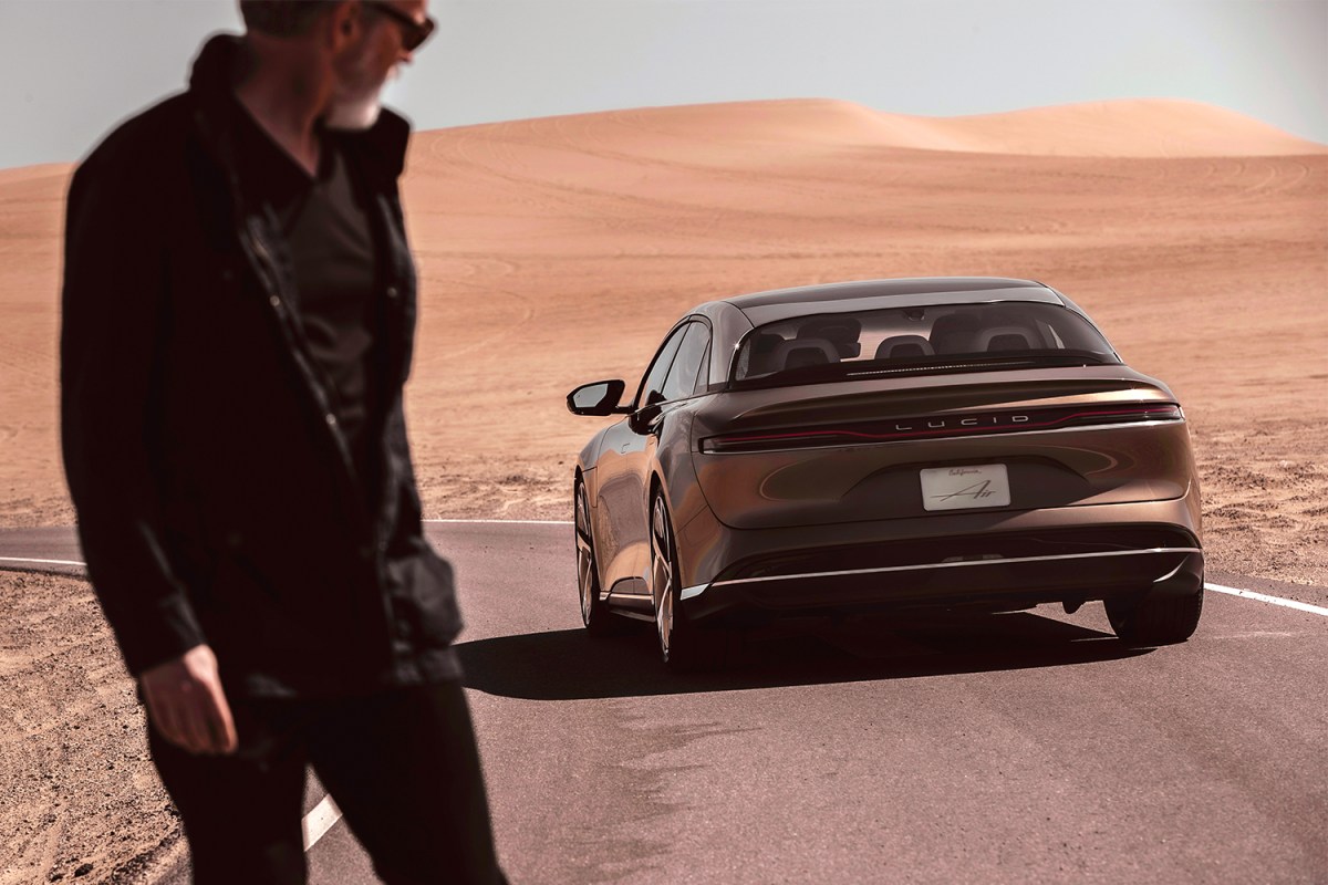 A man in the foreground looking back at the Lucid Air, an electric sedan from Lucid Motors, which recently launched on the stock market thanks to a SPAC merger.