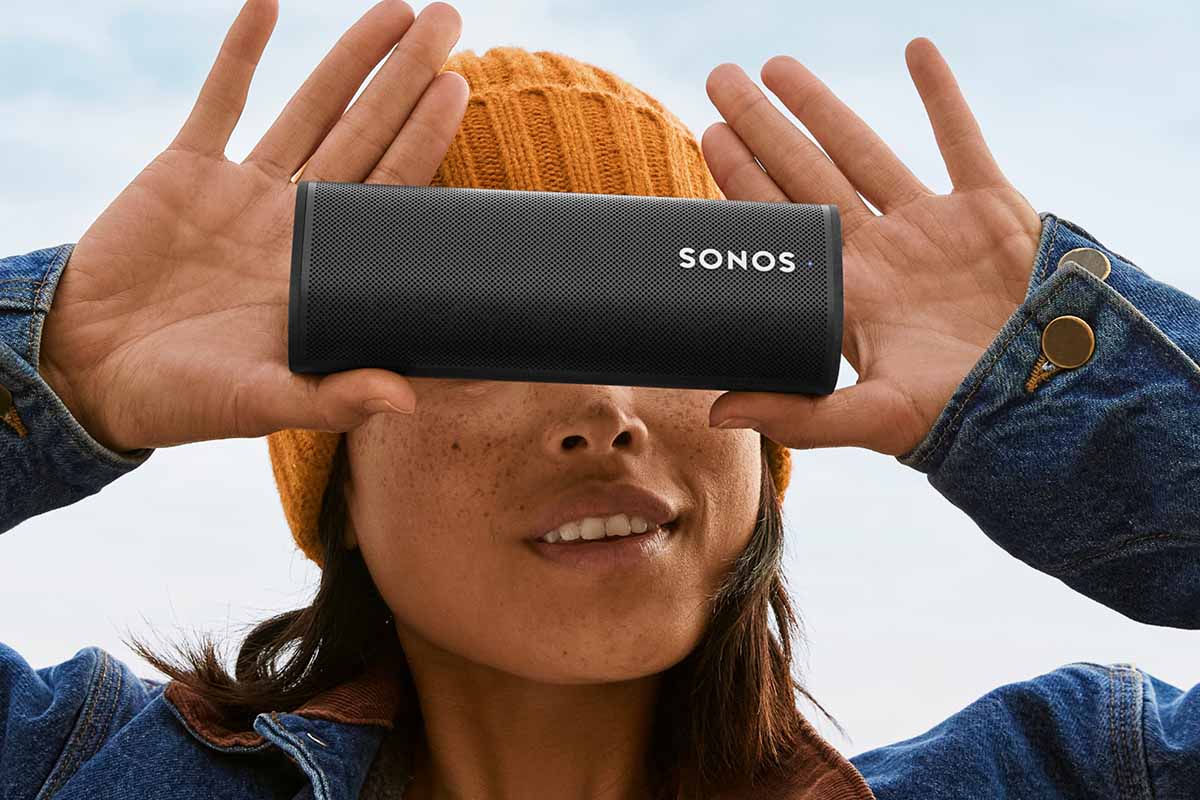 A woman outside holding a Sonos Roam speaker. Sonos teamed up with the North Face to provide outdoor adventure soundscapes on their streaming service.