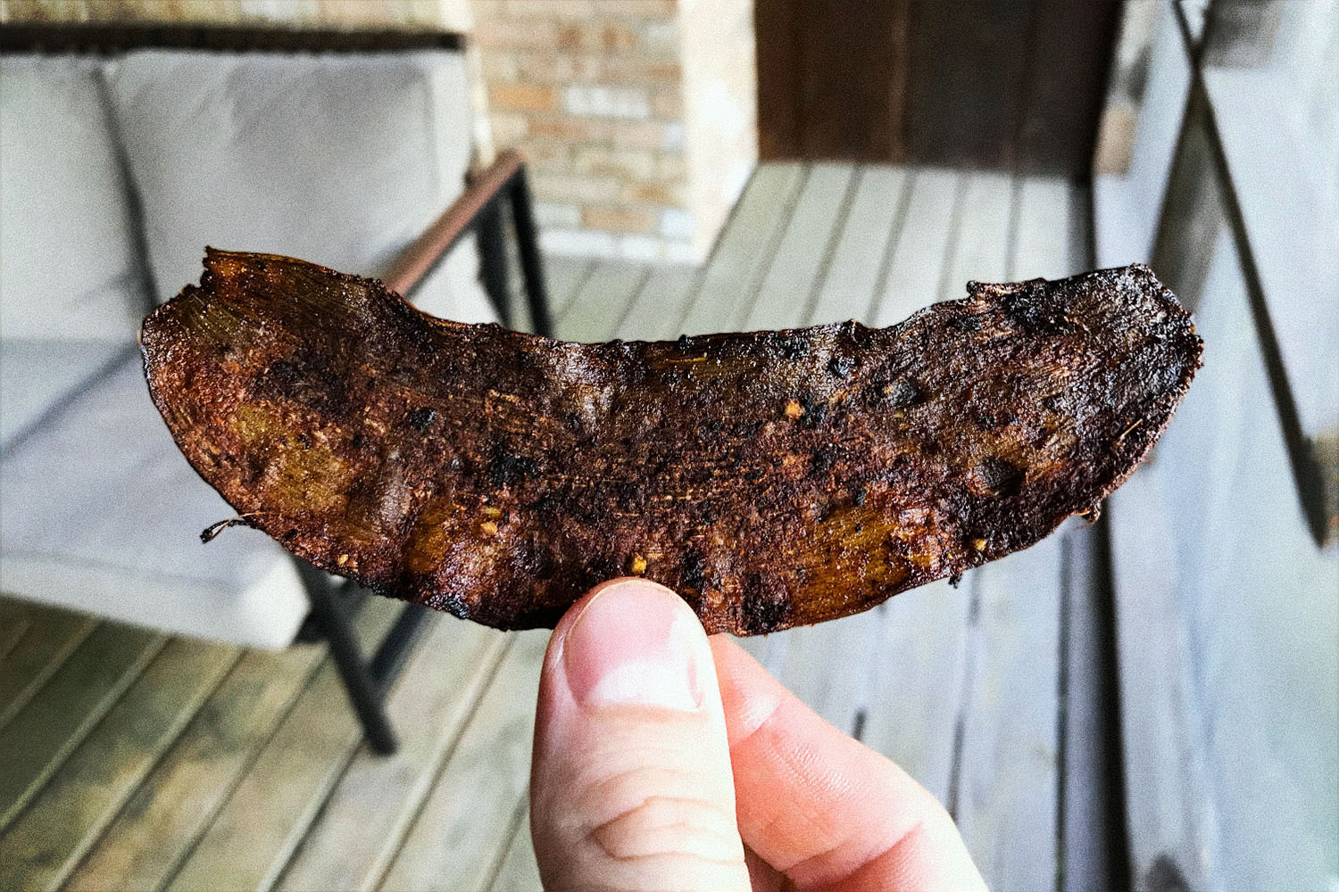 Holding up a crispy piece of banana peel bacon. The fake meat recipe went viral, but is it any good?