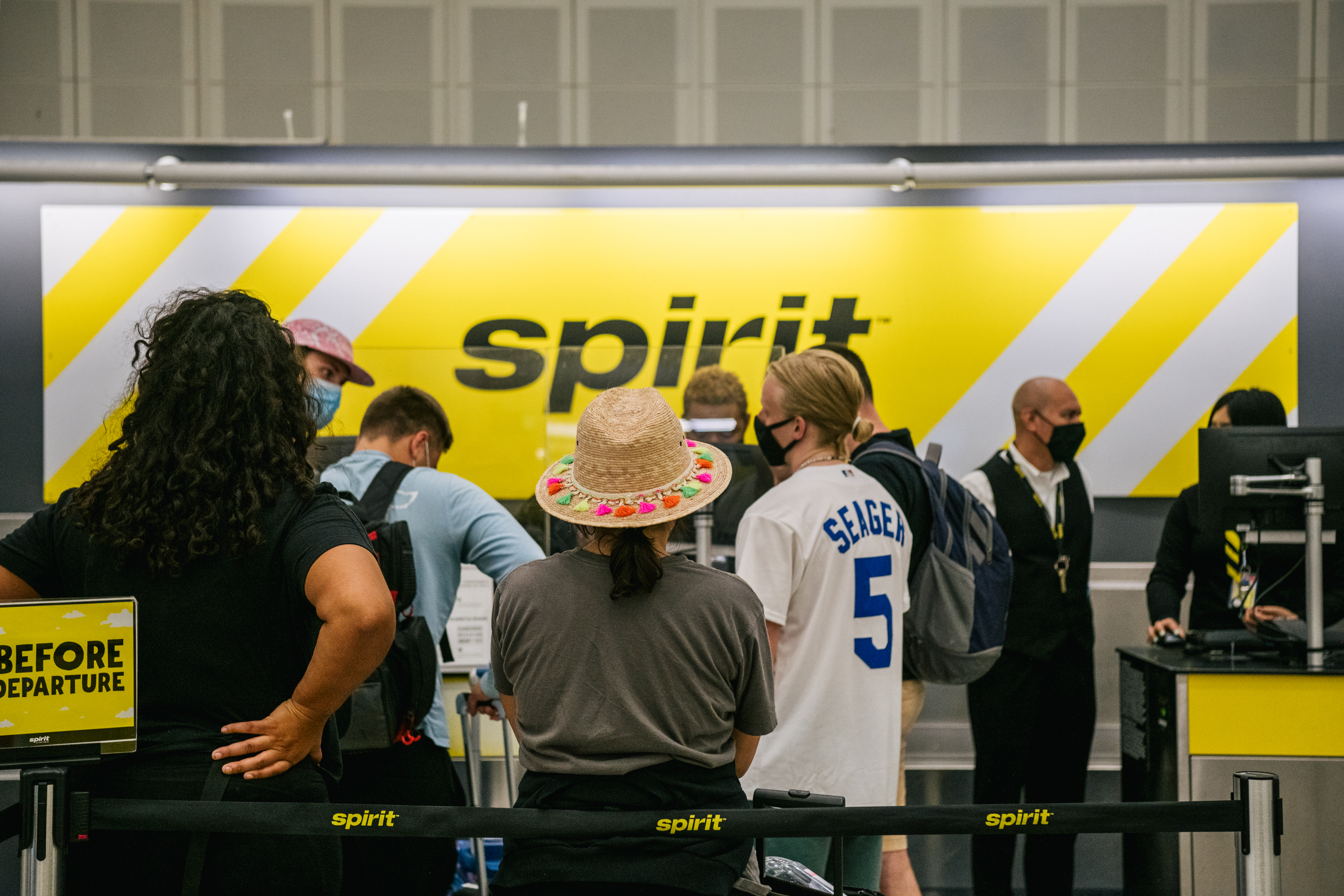 People wait in line at a Spirit Airlines counter at the George Bush Intercontinental Airport on August 05, 2021 in Houston, Texas. Spirit and American Airlines have been forced to cancel hundreds of flights in recent days.