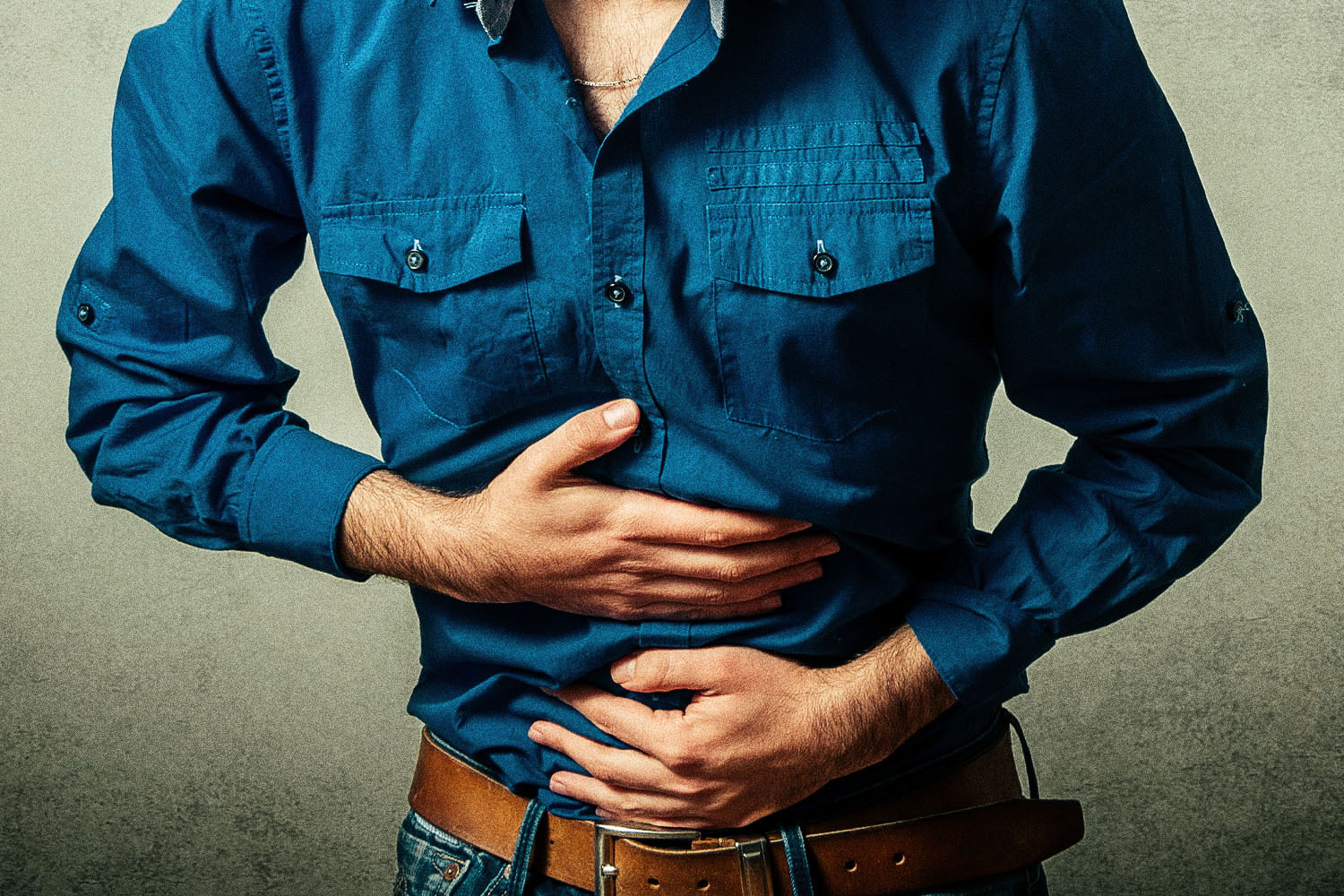 Men are reluctant to discuss gut health; that decision may be killing them. Pictured: A man clutching his stomach.