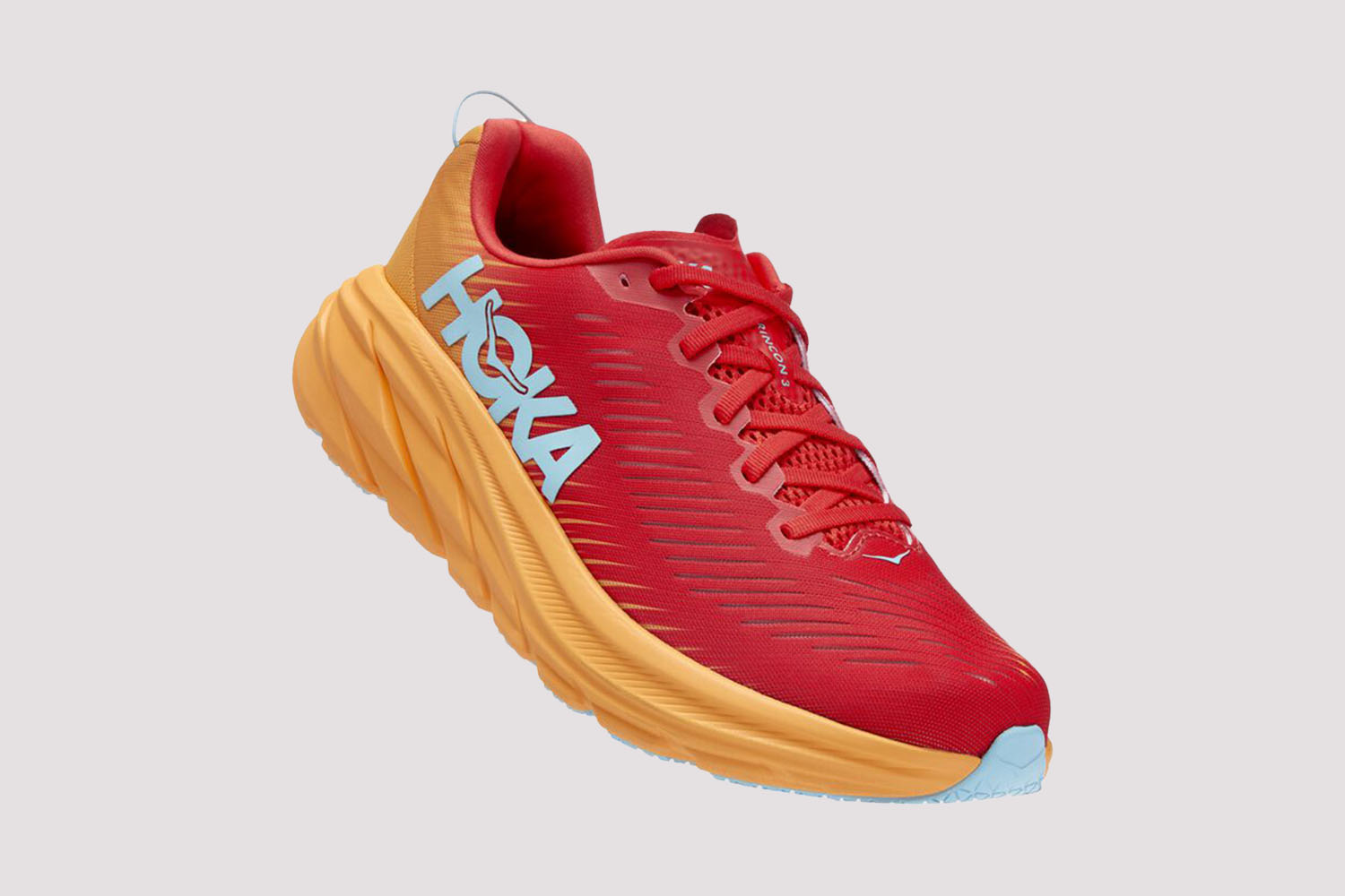 a red, orange, and blue Hoka running shoe on a grey background