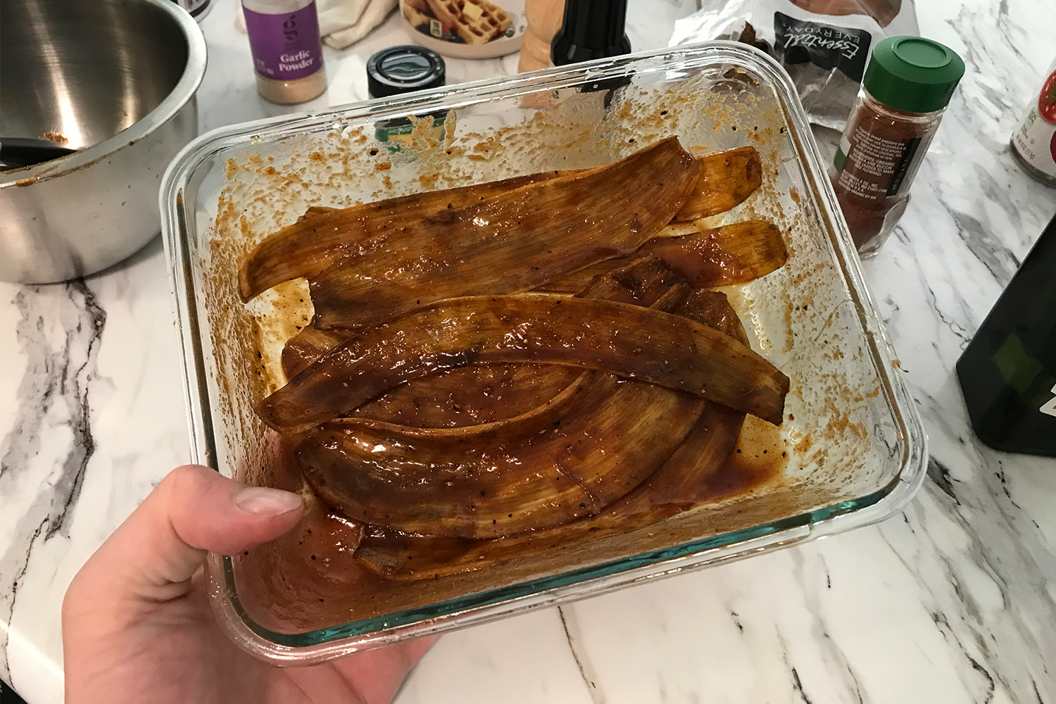 A glass container with marinated banana peels that will be made into banana peel bacon. We talk about how to make the recipe.
