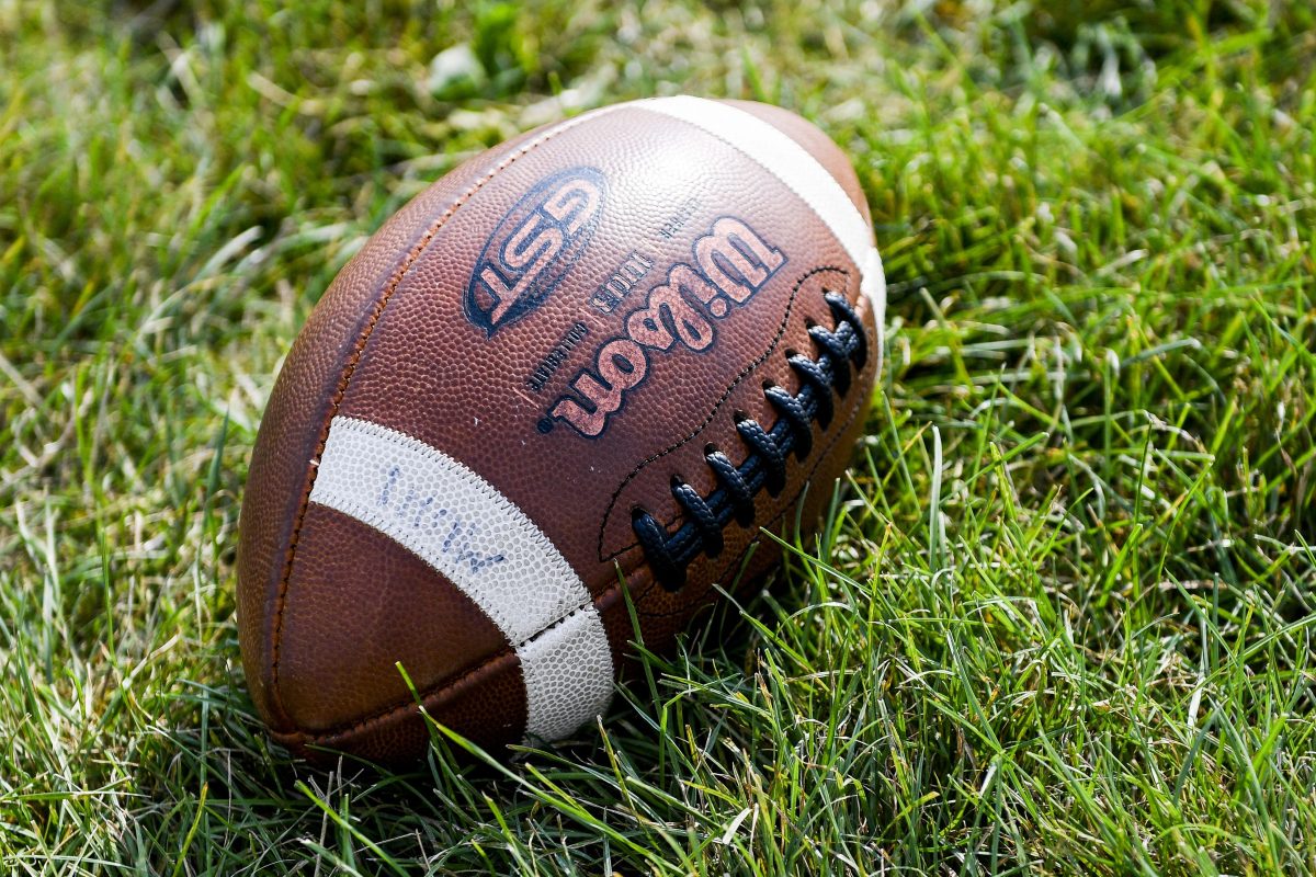 A football sitting on a field. during a high school football game