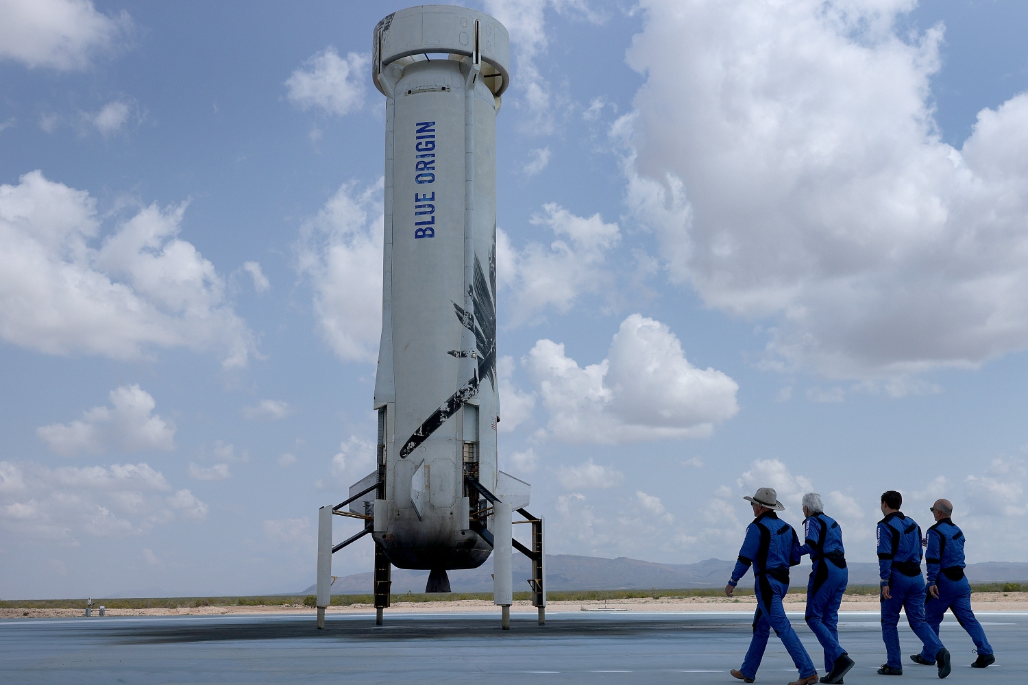 Blue Origin’s New Shepard crew (L-R) Jeff Bezos, Wally Funk, Oliver Daemen, and Mark Bezos walk near the booster to pose for a picture after flying into space in the Blue Origin New Shepard rocket on July 20, 2021 in Van Horn, Texas. Mr. Bezos and the crew were the first human spaceflight for the company. And now you can buy a replica of the rocket for $69.
