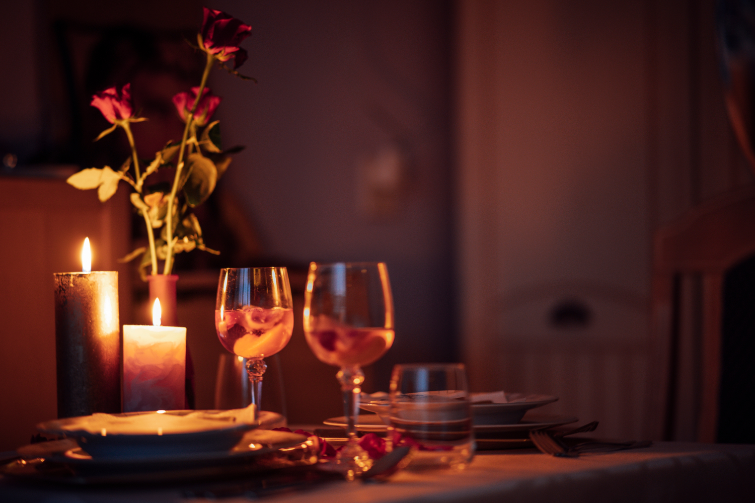 Romantic candle-lit dinner with wine glasses and roses