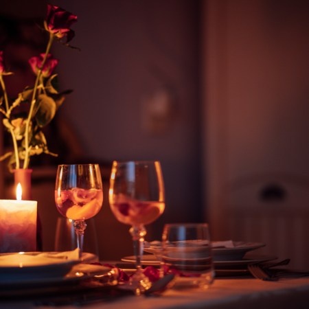 Romantic candle-lit dinner with wine glasses and roses