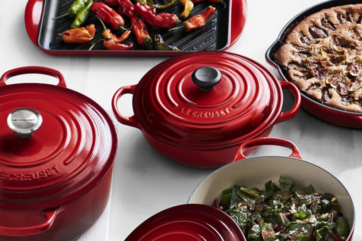 A table full of Le Creuset enameled cast iron cookware. These Dutch ovens, grill pans and skillets are on sale during Williams Sonoma's Warehouse Sale.