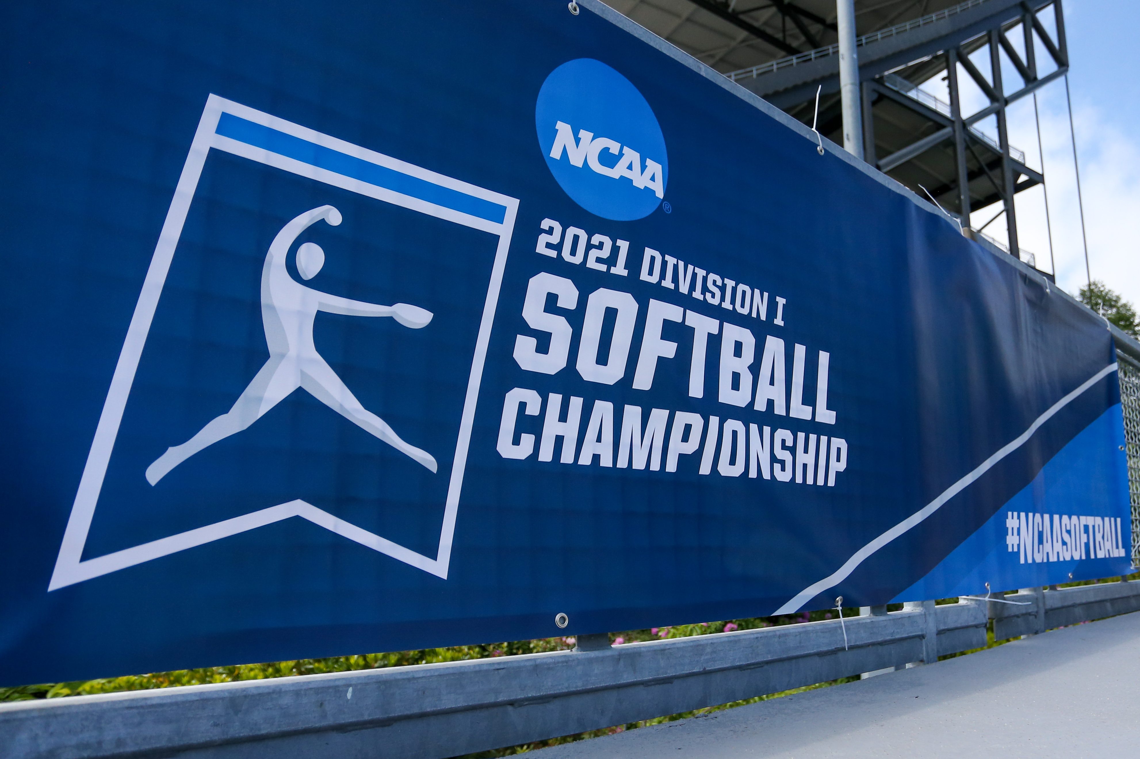 A blue and white banner for the 2021 Division I Softball Championship with the NCAA logo at a game