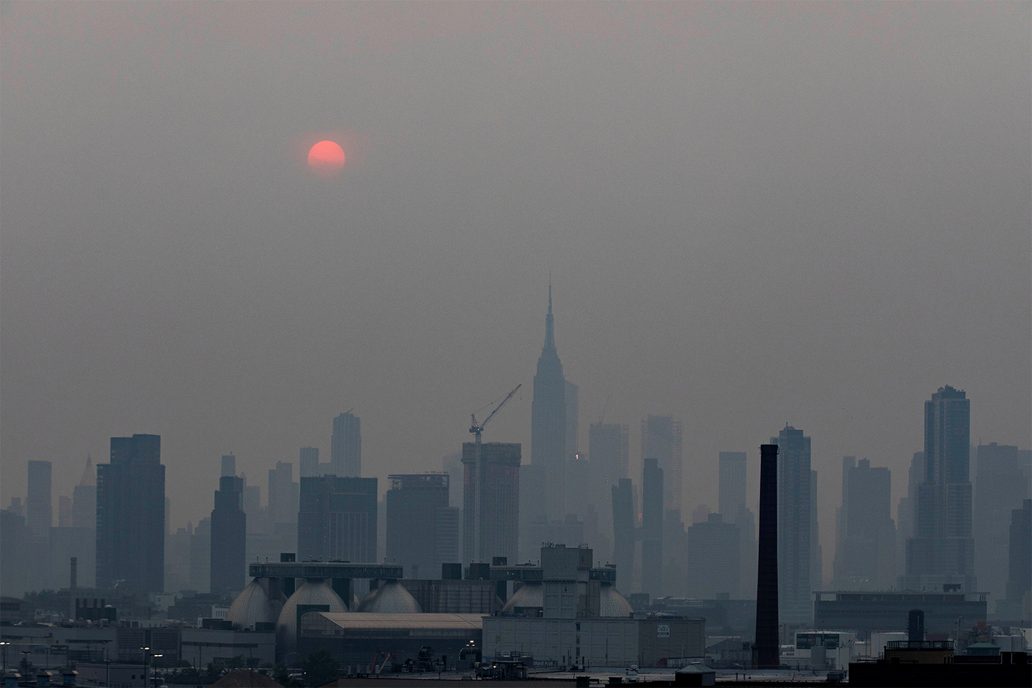 Manhattan skyline and a red sun is seen in a thick haze in New York, the United State, July 20