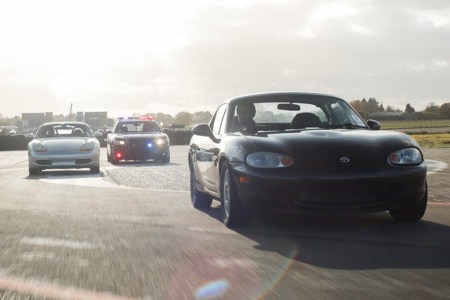 A Mazda MX-5 Miata and Porsche Boxster being chased by a Dodge Charger Police Interceptor. Ever wanted to try outrunning the police? Trackdays offers you the chance to try.