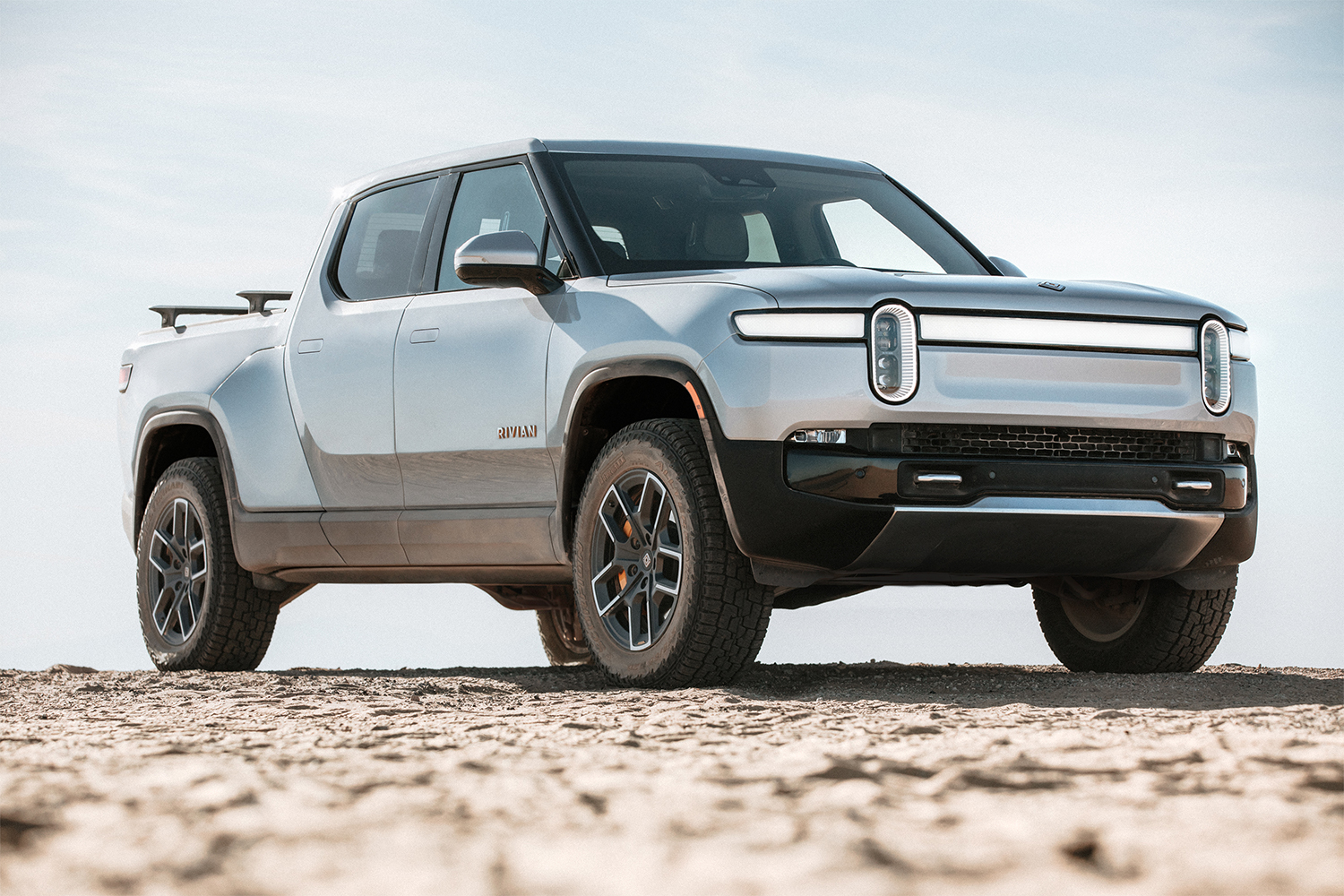 A silver Rivian R1T electric truck sitting still in the desert against a blue sky. The EV company is planning an IPO for November 2021.
