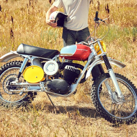 A man in a white T-shirt and blue jeans standing behind a 1968 Husqvarna Viking 360 that was owned by Steve McQueen. The motorcycle will sell at RM Sotheby's Monterey auction.
