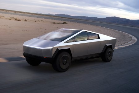 The electric Cybertruck pickup from Tesla driving down a road in the desert. We suggest a moratorium on Cybertruck news until Elon Musk's company actually builds it.