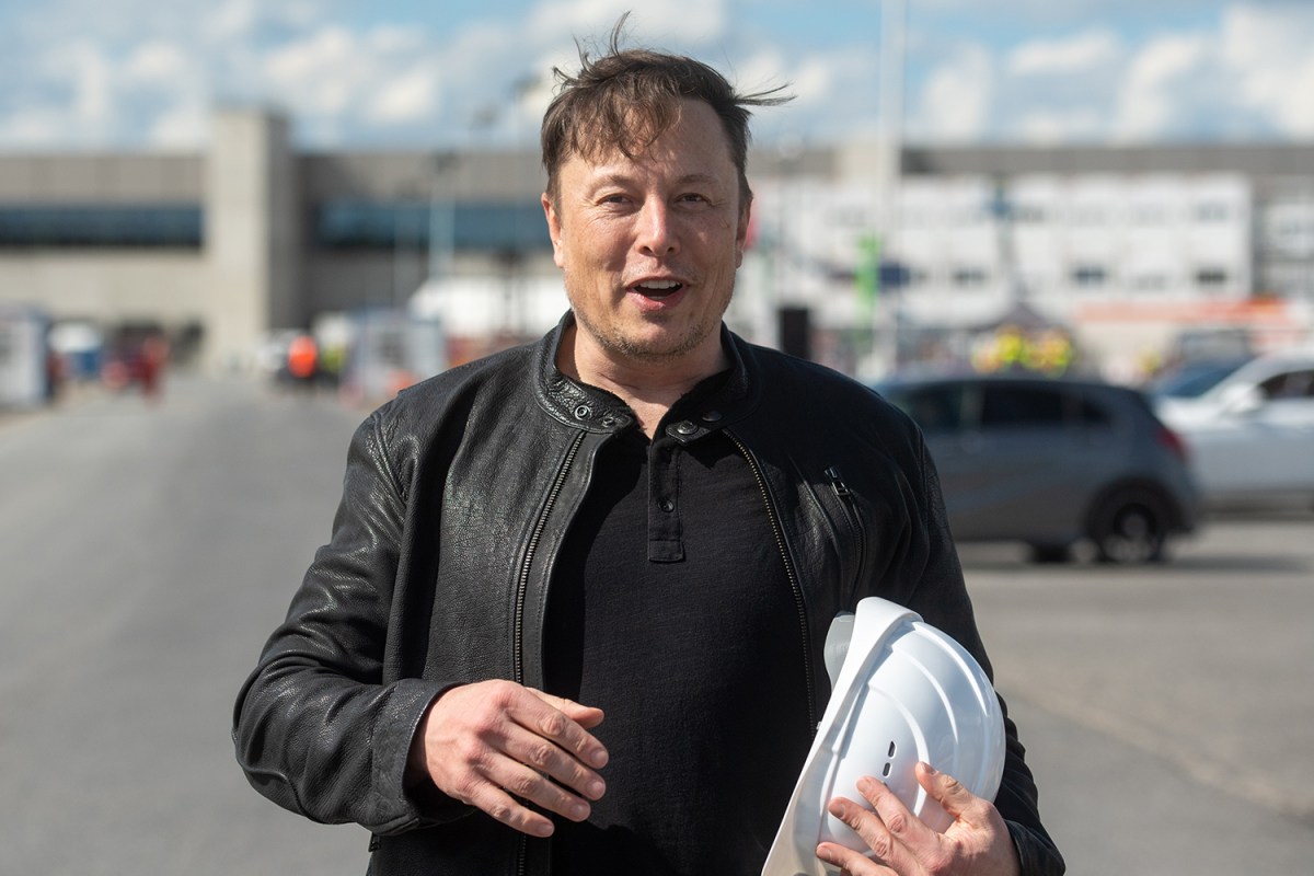 Tesla CEO Elon Musk holding a white hard hat while visiting a new electric car factory in Germany near Berlin in May 2021. He was the highest paid executive in the US in 2020 according to Bloomberg.