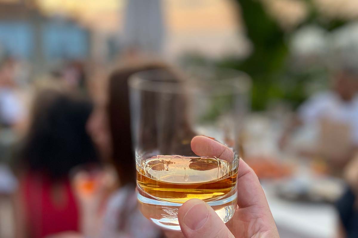 A glass of Basil Hayden Toast in front of a blurry background of NYC