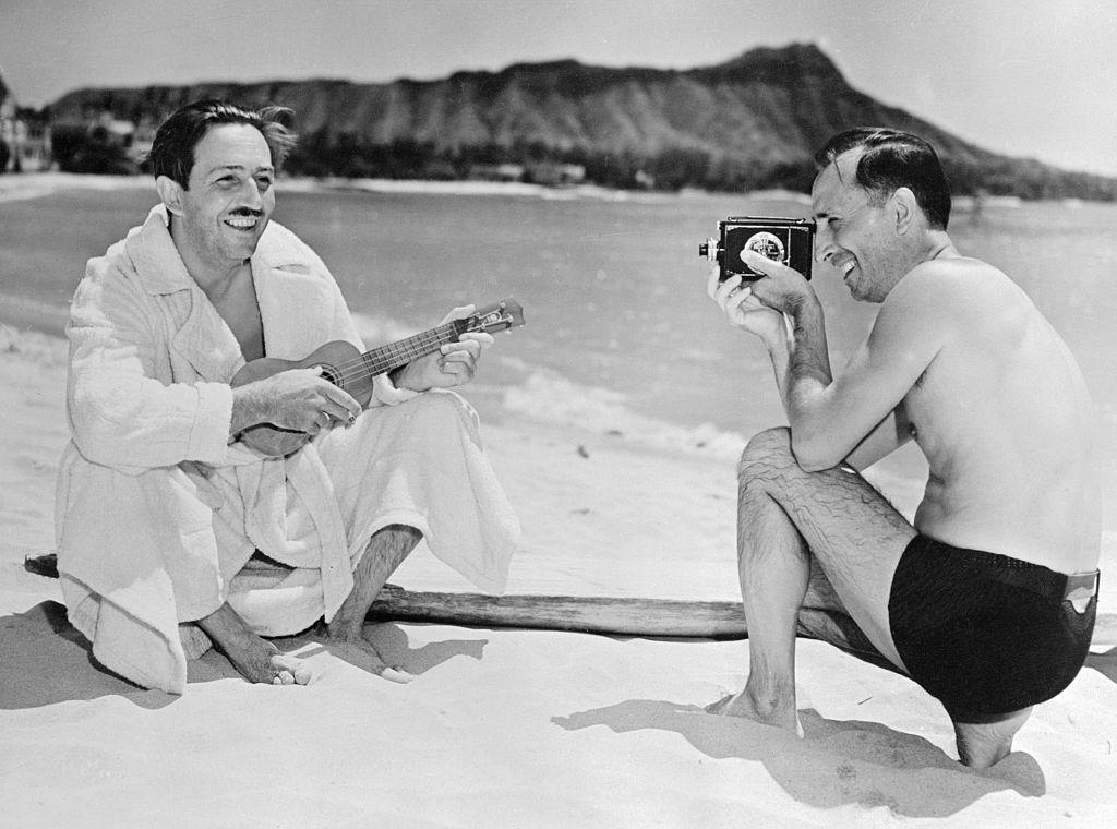 Walt and Roy Disney on the beach in a black and white photo. The brothers' first house in Los Angeles is undergoing a restoration.