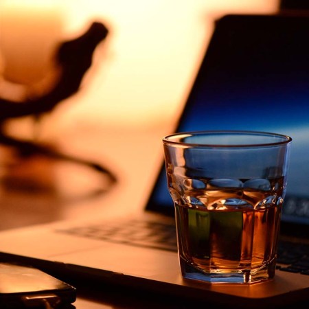 Whiskey, laptop and a smartphone on a desk. Whisky investment is entering the digital space.