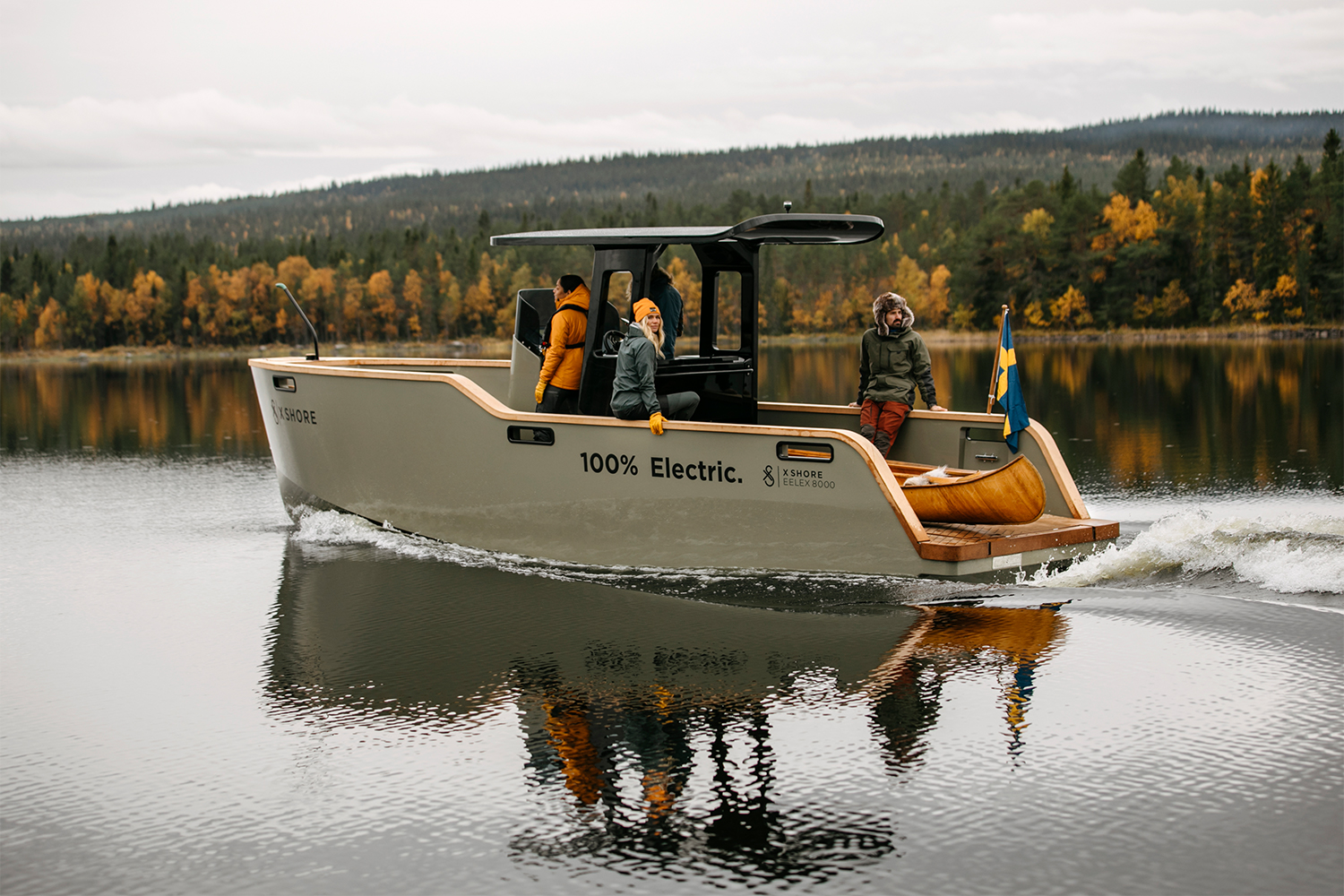 The 100% electric Eelex 8000 from X Shore slowly gliding through still water with fall foliage in the background. The Swedish electric boat builder hopes to be a leader in the industry.