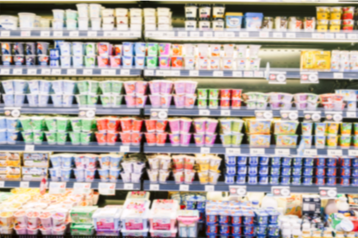 A blurry yogurt aisle in a grocery store. 