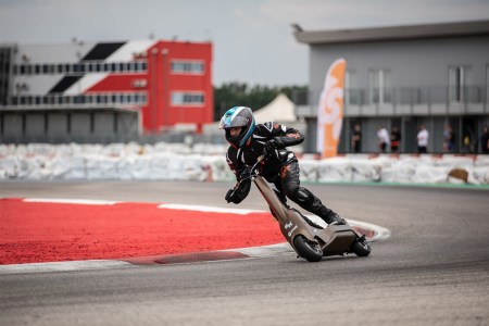 A man rides an electric scooter on a racetrack, testing for the new eSkootr Championship