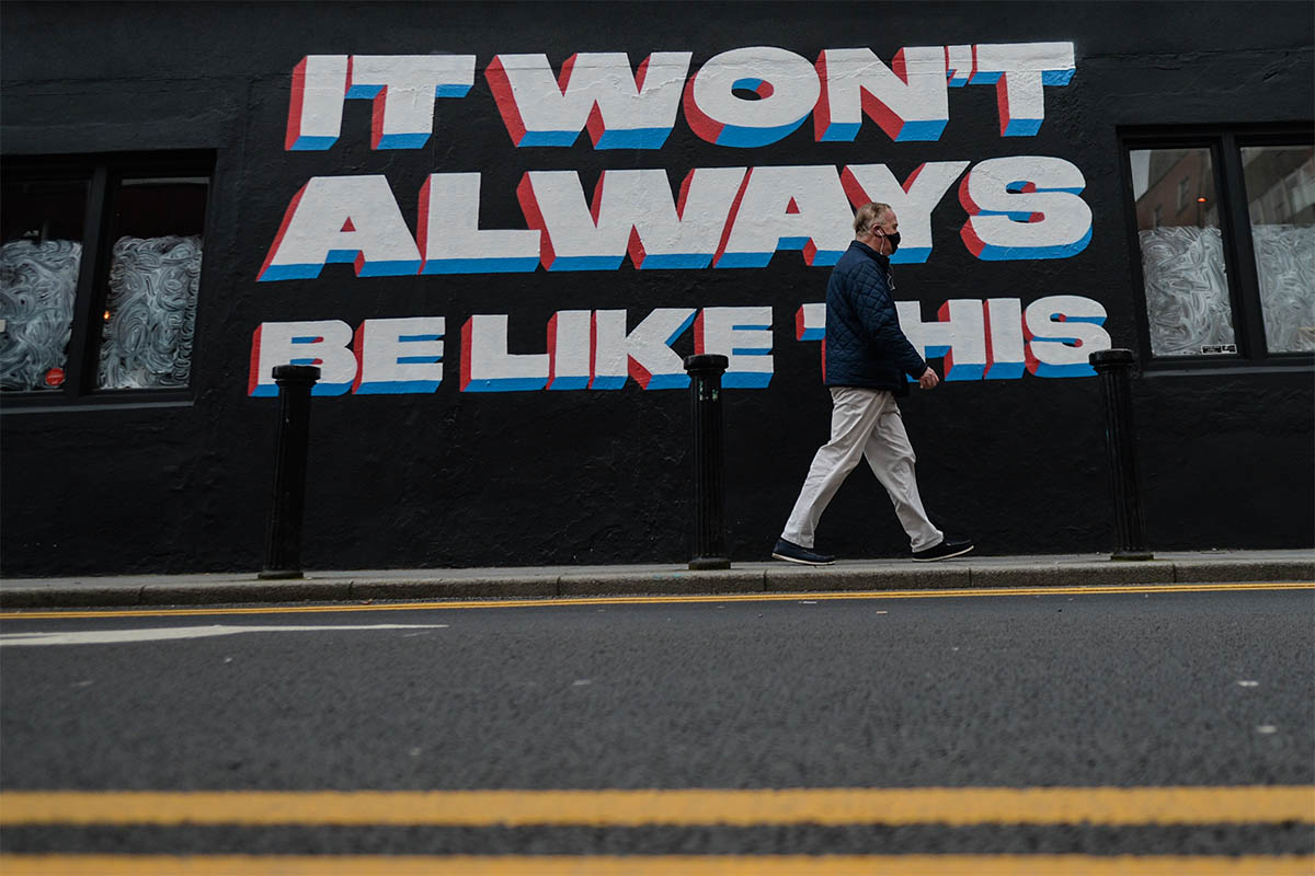 A man walks past a COVID sign in Dublin.