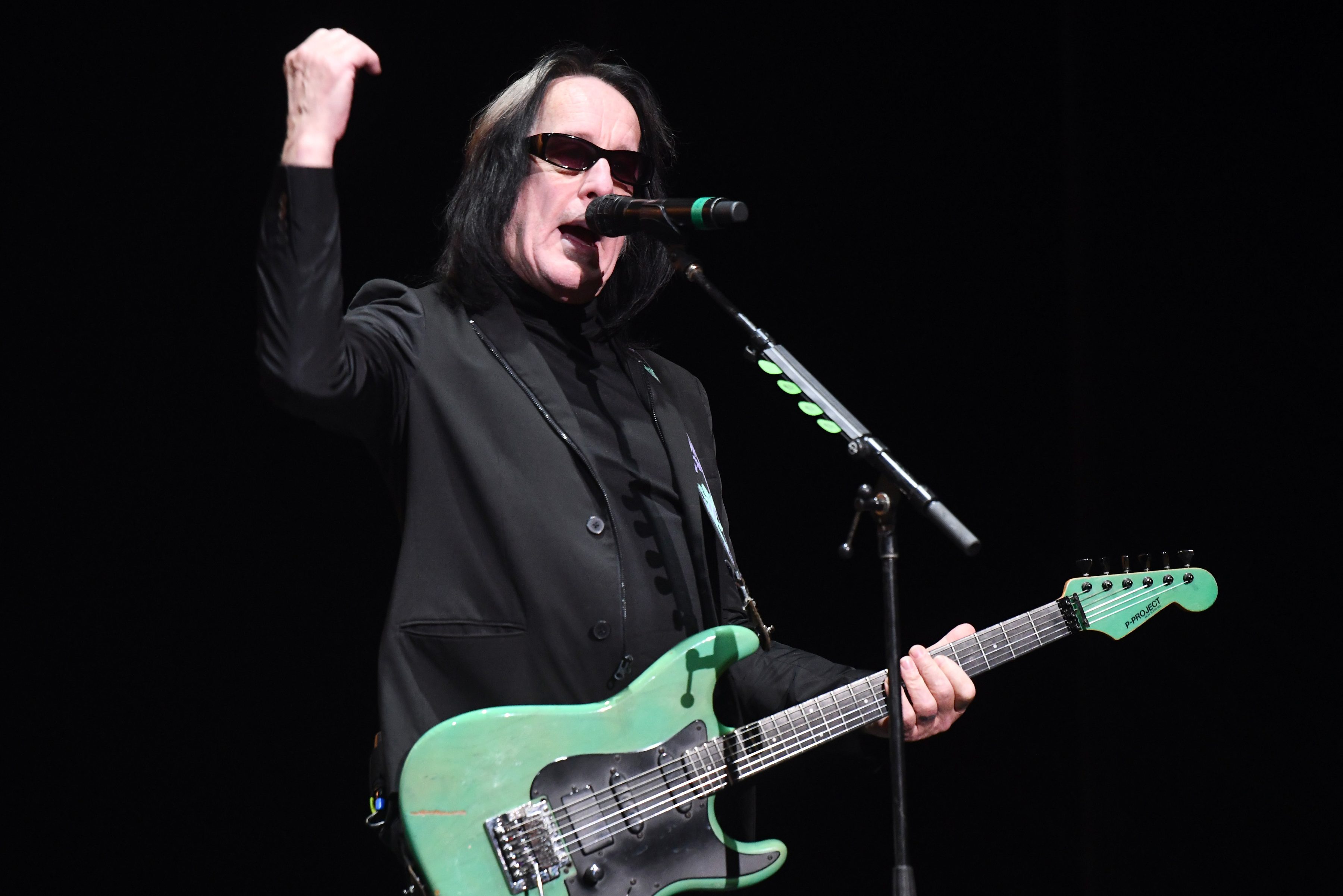Todd Rundgren wearing sunglasses and holding a mint green guitar performs onstage during the 50th anniversary tribute tour celebrating The White Album at The Wiltern on December 11, 2019 in Los Angeles, California