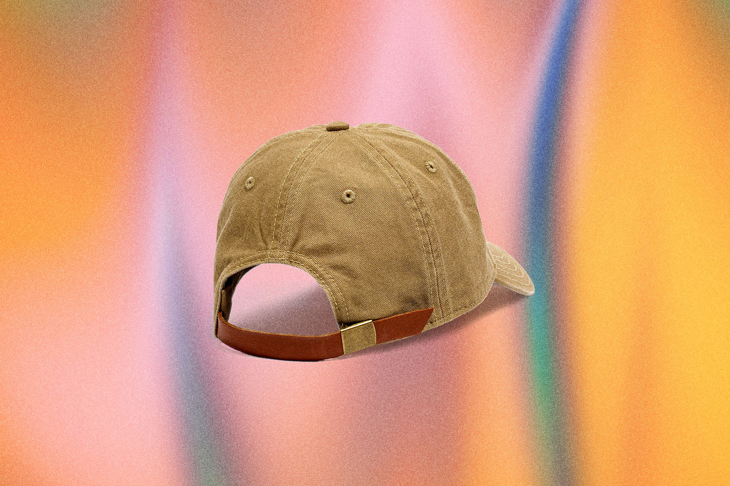A light brown backwards baseball cap from Madewell on a multi-colored backdrop