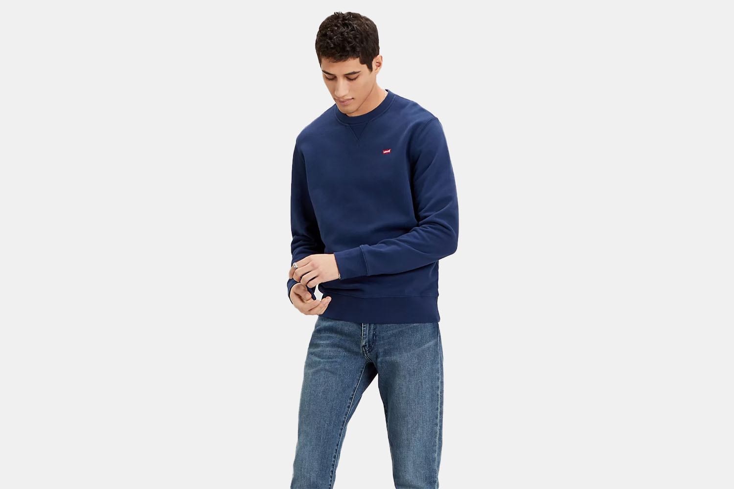 A model wearing a navy Levi's relaxed crewneck sweater.