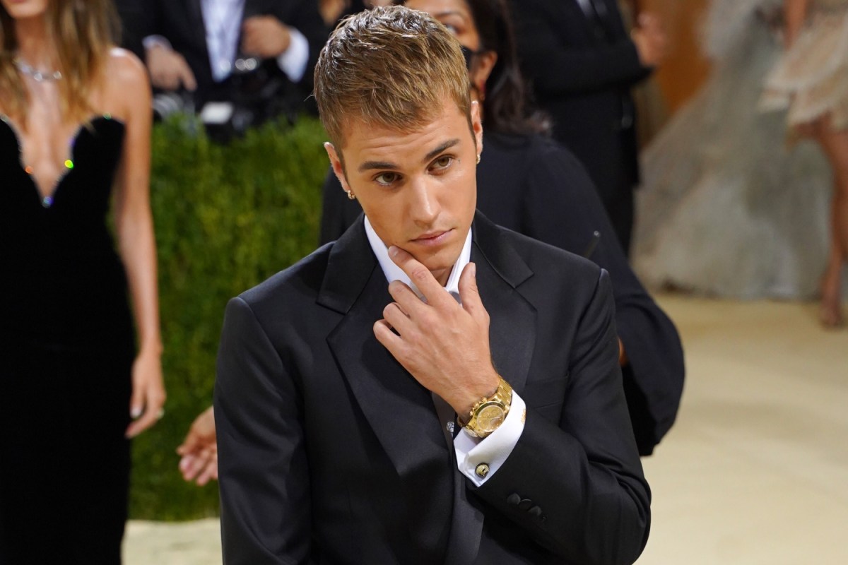 Justin Bieber poses, chin and hand, at the 2021 Met Gala
