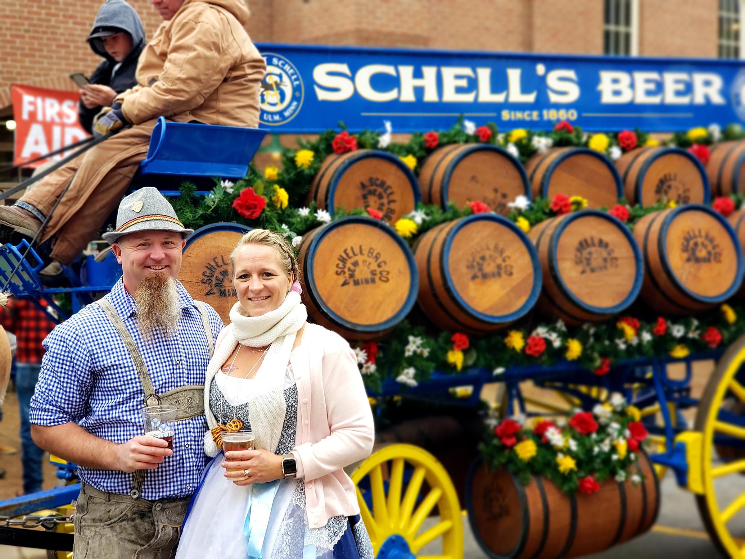 A couple drinks beer in front of Schell's Beer at Oktoberfest in New Ulm.