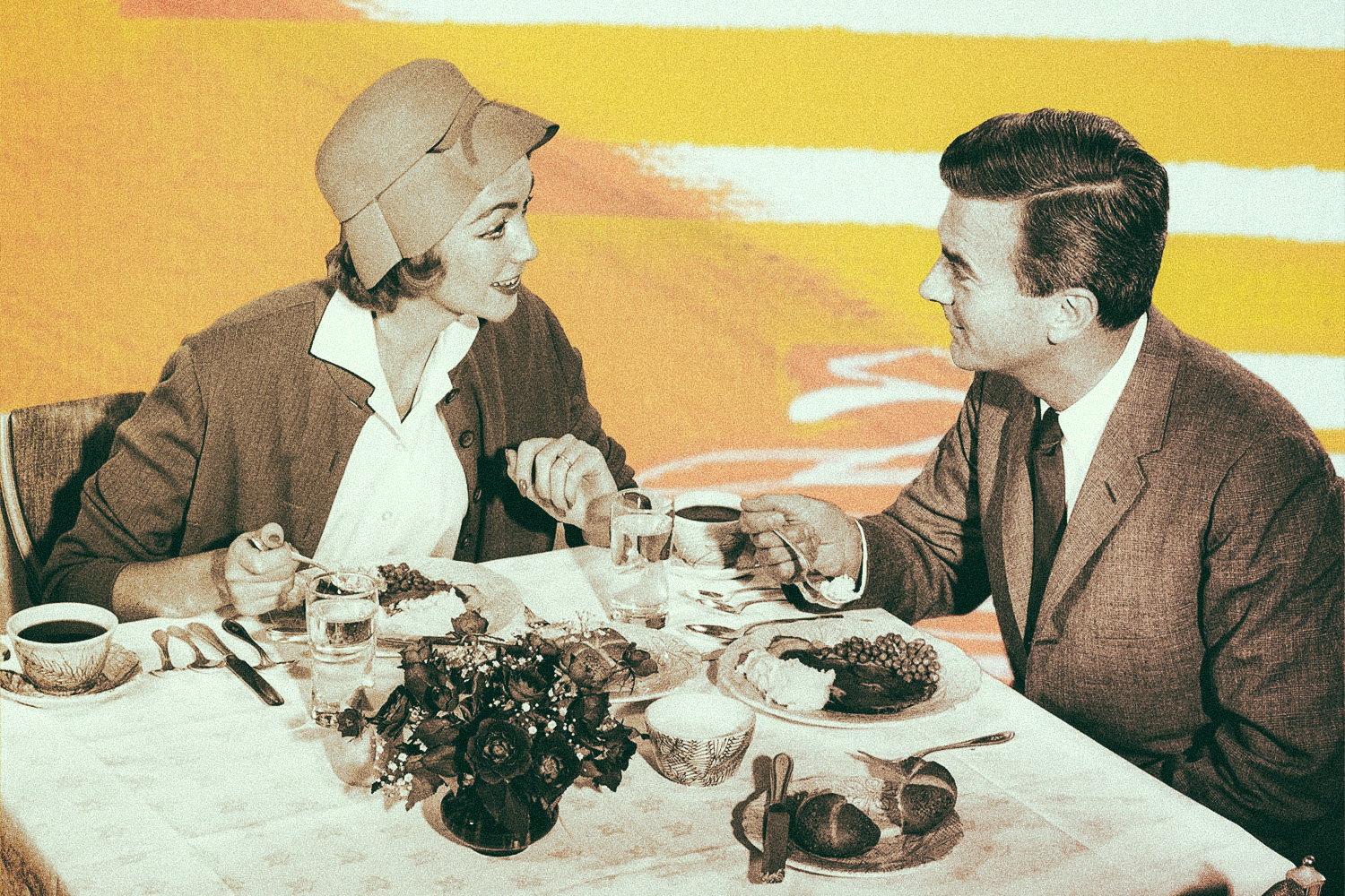 Black and white photos shows a circa-1920s couple at a restaurant
