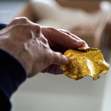 A man holding a piece of Iron Age gold found by Danish rookie treasure hunter Ole Ginnerup Schytz and to be exhibited at the Vejlemuseerne in Denmark