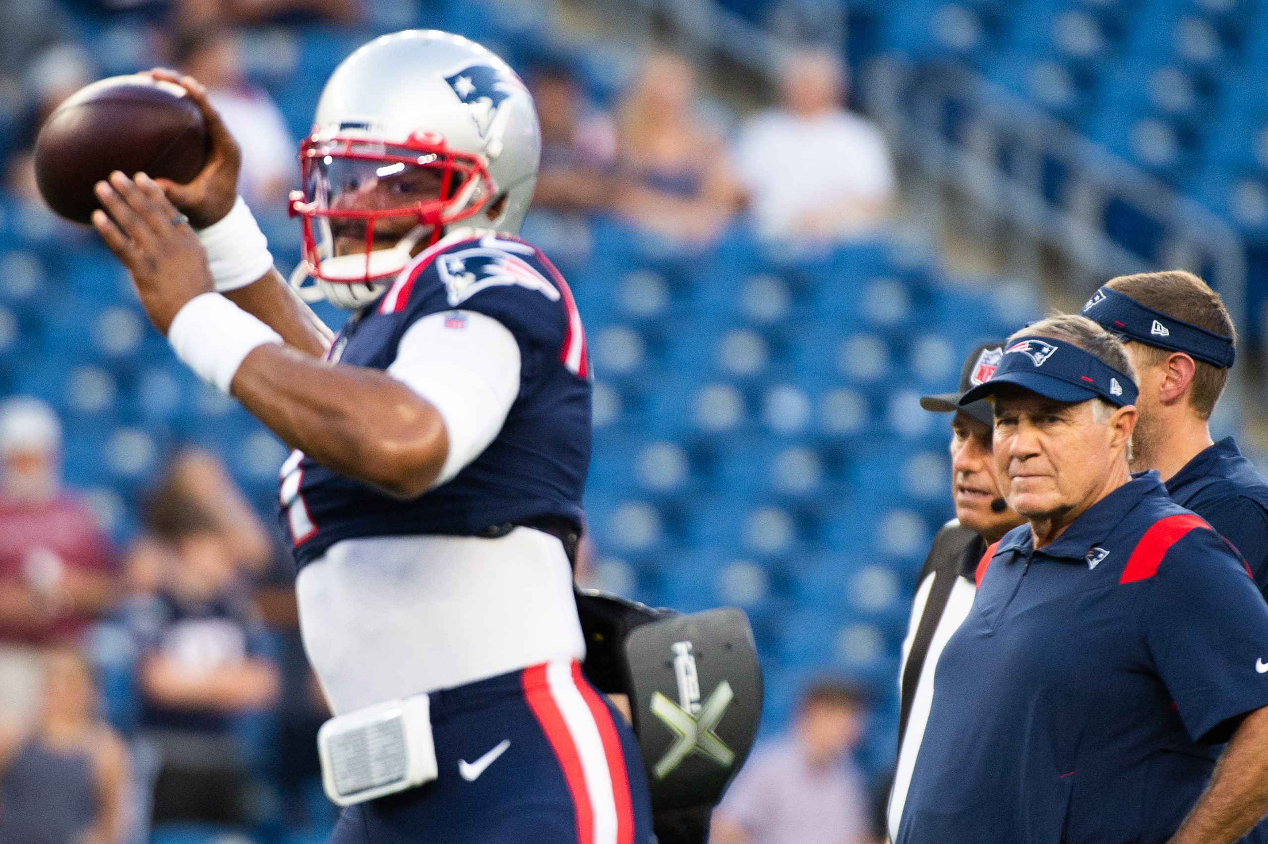 Patriots head coach Bill Belichick watches Cam Newton, who has been cut, warm up
