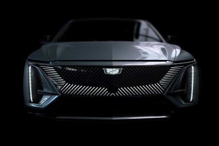 The front end of the new 2023 Cadillac Lyriq, the GM brand's first all-electric SUV, in a black room