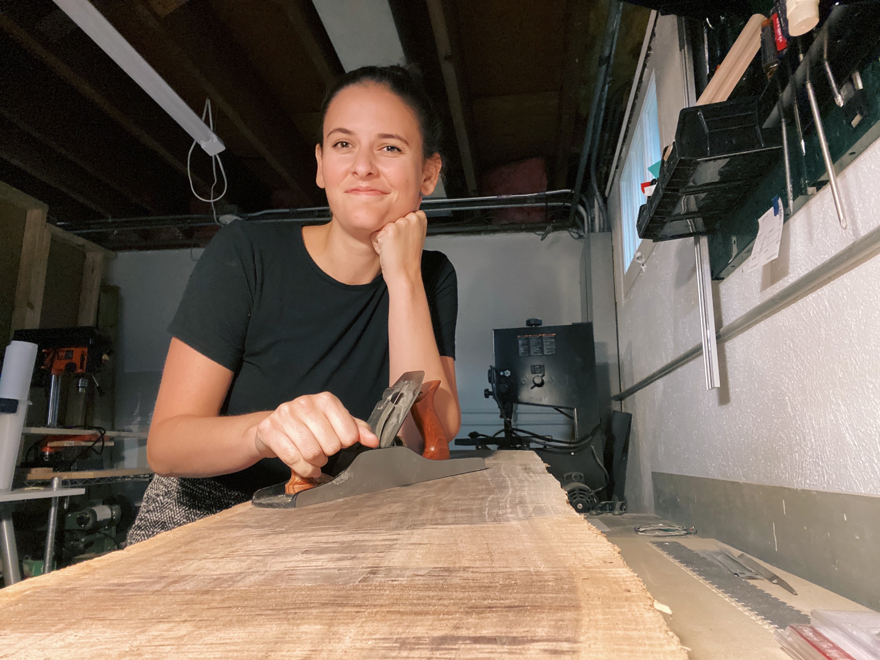 writer claire young hand-planes a piece of black walnut wood at her home in chicago