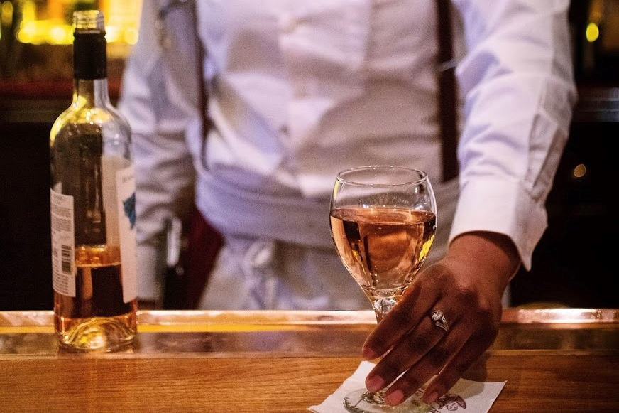 A bartender serves a glass of rosé at the Old Ebitt Grill in DC