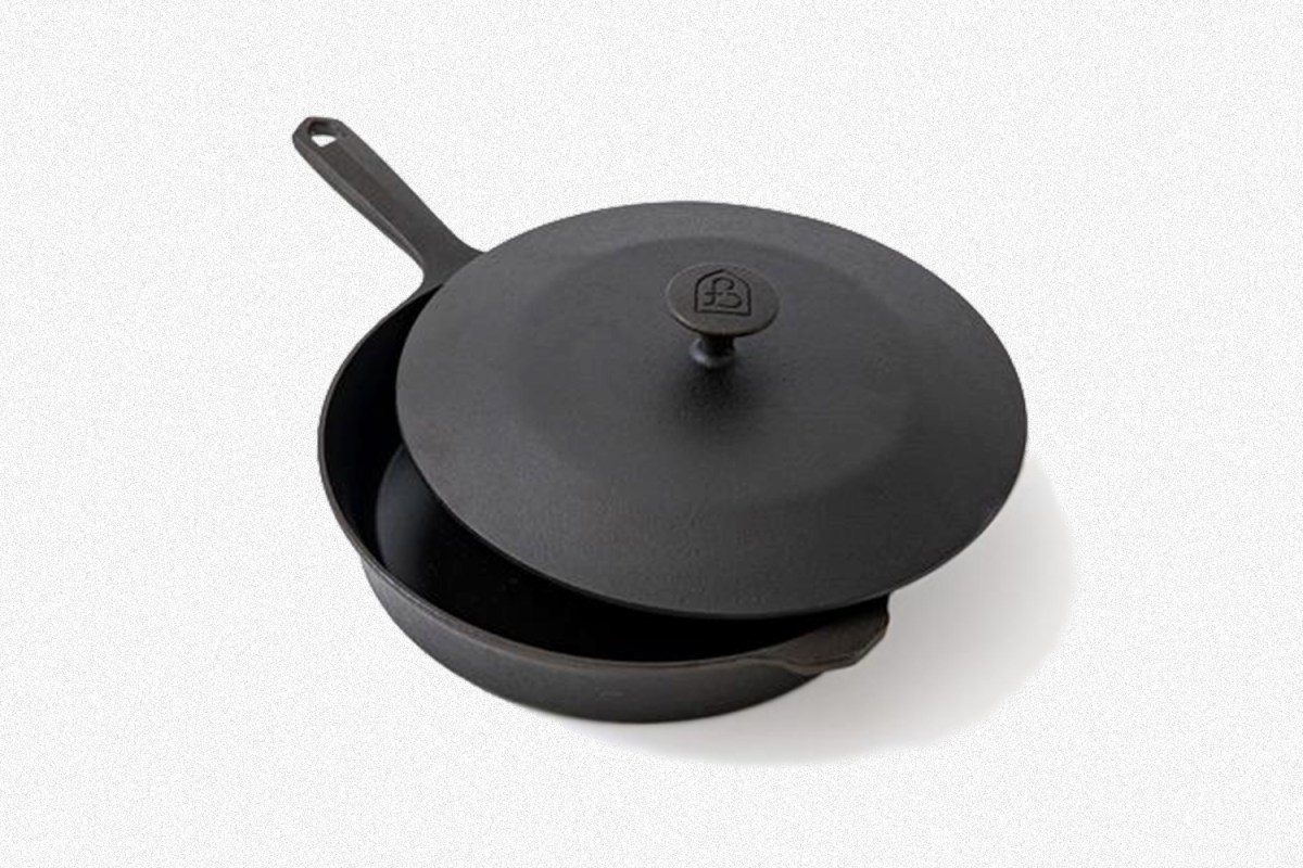 A cast iron skillet with a matching lid from American brand Field Company on a grey background